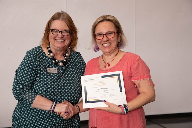 Two people holding a certificate